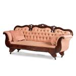 The carved-leaf crest, scrolled arms, castors and tufted upholstery are seen on mid-Victorian furniture. This sofa was made attributed to H.B Mudge Furniture Co. in Ohio, an important furniture company working in the 1880s. (Photo courtesy of Cowles Syndicate Inc.)