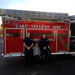 Owen Hanuse (center) placed the winning bid in a Lake Stevens Fire silent auction to benefit Operation Warm. Owen received a ride to school on a fire engine and the use of the Lake Stevens Firefighter&rsquo;s Vikings Super Fan Fire Helmet for the spring sports season. (Contributed photo)