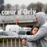 Travelers hug outside Orly airport after a shooting there Saturday. (AP Photo/Kamil Zihnioglu)