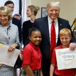 President Donald Trump and Education Secretary Betsy DeVos pose with fourth graders during a tour of Saint Andrew Catholic School on Friday in Orlando, Florida. (AP Photo/Alex Brandon)
