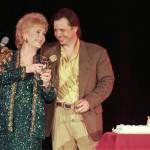 In this April 1997 photo, Debbie Reynolds celebrates her 65th birthday on stage as her son, Todd Fisher, presents her with a cake at the Debbie Reynolds Hotel in Las Vegas. (AP Photo/Lennox McLendon, File)
