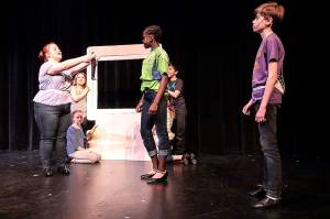 Madrona Children&rsquo;s Theatre is celebrating its 25th year with a production of &ldquo;Willy Wonka&rdquo; this weekend in the theater at Mountlake Terrace High School. In rehearsal, Logan Bury as Charlie looks on as Mrs. Teavee (Naomi Machyo) sees that her son Mike Teavee has shrunk.