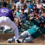 The Mariners&rsquo; Leonys Martin (right) scores past Rockies relief pitcher Yency Almonte on a wild pitch during the third inning of a spring game on March 4, 2017, in Scottsdale, Ariz. (AP Photo/Chris Carlson)