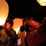 Baylee and Frank Hadaway work Wednesday evening to launch lanterns in memory of those who died in the Oso mudslide. (Kevin Clark / The Herald)