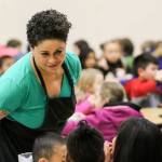 Lisa Gaines, the Nutrition Services lead at Challenger Elementary School in Everett, walks the aisles and talks to students during lunch. (Kevin Clark / The Herald)