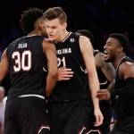 South Carolina forward Maik Kotsar (21) is congratulated by forward Chris Silva (30) after scoring against Florida during the second half of the East Regional championship game of the NCAA men&rsquo;s college basketball tournament, Sunday, March 26, in New York. (AP Photo/Julio Cortez)