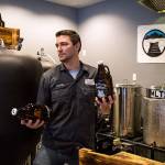Co-owner Jason Parzyk carries two growlers to fill as he serves up beer at Lake Stevens Brewing Co., the first brewery in the city. (Andy Bronson / The Herald)