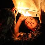 Hailey Norris and Zach Brunner work to launch a lantern. (Kevin Clark / The Herald)