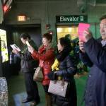 In this March 27 photo, tourists from China take pictures at the New England Aquarium in Boston. (AP Photo/Elise Amendola)