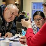 Andrey Matveev (from left), Kathy Yu and Susan Yu look over examples. (Kevin Clark / The Herald)