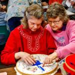 Karen Harper (right) assists her sister, Leslie Venables, with sewing Tuesday at Quilceda Community Services. A founding board member, Harper wanted to care for her sister and has done so from the beginning. (Dan Bates / The Herald)
