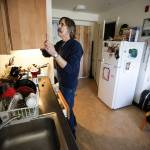 Dennis Bateman, 63, opens a cupboard while making coffee in the kitchen area of his studio apartment at Patrick Place on Aurora Avenue North in Seattle on Wednesday, Feb. 1. Three years ago, Bateman moved into the building addicted to heroin but found that having a safe place to sleep for the first time in his life was crucial to getting sober, which he is now. (Ian Terry / The Herald)