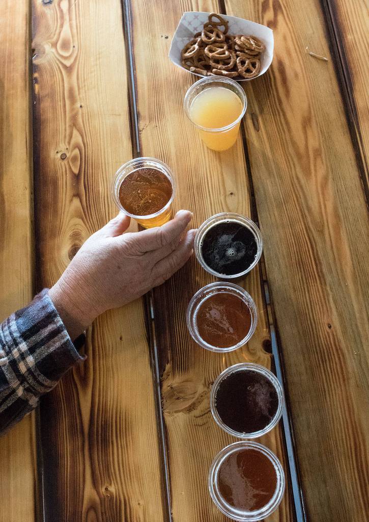 A customer tries a flight of beers and one cider at Lake Stevens Brewing Company, the first brewery in the city, on Thursday, Feb. 23, in Lake Stevens. (Andy Bronson / The Herald)