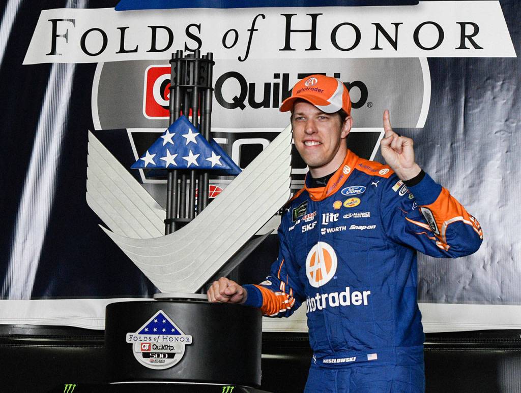 Brad Keselowski poses with the trophy in victory lane after winning a NASCAR Monster Cup series auto race at Atlanta Motor Speedway in Hampton, Ga., Sunday, March 5. (AP Photo/John Amis)