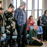 Charles Link kneels in prayer in the closing minutes of service. (Kevin Clark / The Herald)