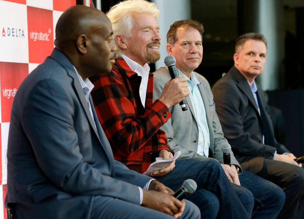 Richard Branson (second from left), founder of Virgin Atlantic and the Virgin Group, speaks at a news conference as he sits with Lance Lyttle (left), Managing Director of the Port of Seattle; Craig Kreeger (second from right), CEO of Virgin Atlantic; and John Caldwell (right), Seattle vice president of Delta Air Lines, on Monday, March 27, at Sea-Tac Airport. (AP Photo/Ted S. Warren)