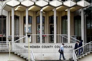 A handful of people come and go at the main entrance to the Snohomish County Courthouse late Monday afternoon. (Dan Bates / The Herald)