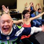 Larry Berg (nearest) enthusiastically helps Willow Place actifvity manager Rachel Hawkins (center) lead a modified yoga class early Tuesday at Quilceda Community Services in Marysville. (Dan Bates / The Herald)