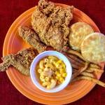 A carryout from Popeyes Louisiana Kitchen displayed on a plate at home has New Orleans style chicken, buttermilk biscuits, Cajun fries and macaroni and cheese. (Andrea Brown/The Herald)
