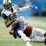 Washington&rsquo;s Dante Pettis (8) is tackled by Alabama&rsquo;s Anthony Averett (28) during a College Football Playoff semifinal on Dec. 31, 2016, in Atlanta. Pettis is competing in the long jump with the UW track team this spring. (AP Photo/Skip Martin)