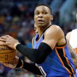 Oklahoma City&rsquo;s Russell Westbrook (0) spins around Phoenix&rsquo;s Devin Booker during the first half of the Suns&rsquo; 120-99 win over the Thunder on Friday in Phoenix. Westbrook became the second player to average a triple-double for a full season in the loss. (AP Photo/Matt York)