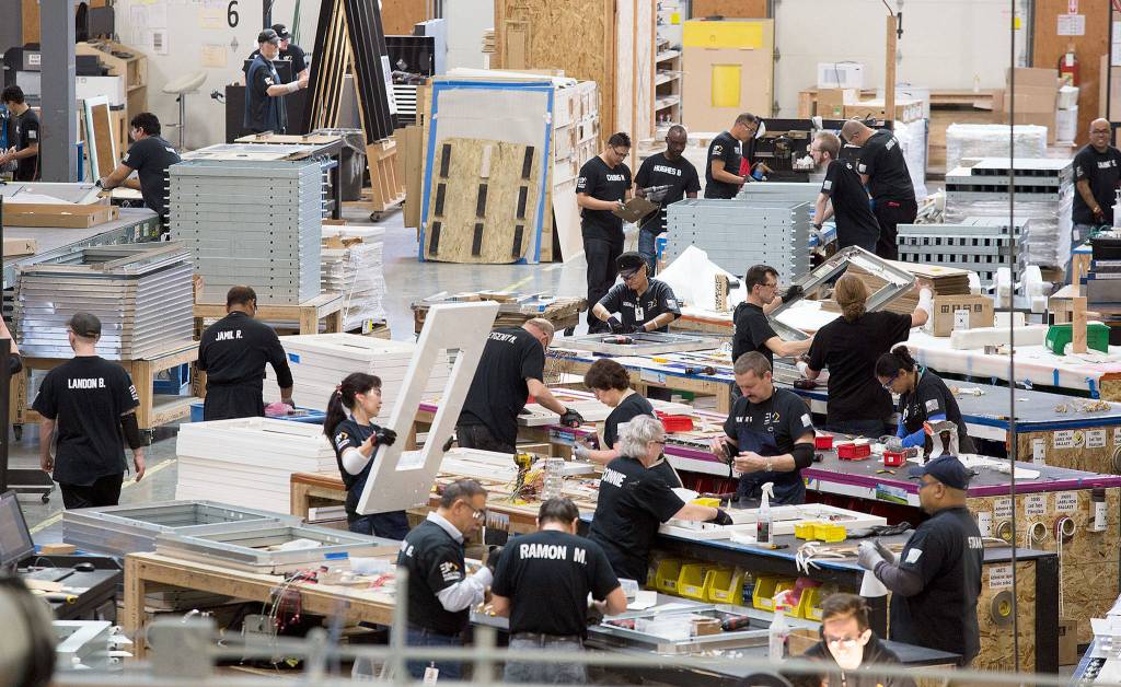 Employees at Electric Mirror assemble custom-made mirrors, with lights and TV screens inside them, Monday in Everett. Electric Mirror has filed complaints with the U.S. International Trade Commission against five companies. (Andy Bronson / The Herald)