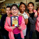 Along with their Madison Elementary School classmates, Jaedin Chum (left), Alfonso Moreno, Jaimy Moreno, Jaila Snowden, Daisy Padilla and Julissa Lopez are selling cookbooks with recipes from their teachers and parents to help pay their way to Camp Orkila on Orcas Island for fifth-grade outdoor camp. Jaimy Moreno, holding the cookbook (center), is tied with one other fifth-grader in sales thus far. (Dan Bates / The Herald)