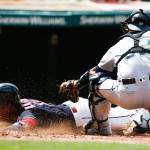 Cleveland&rsquo;s Jose Ramirez slides past Seattle Mariners catcher Carlos Ruiz on a sacrifice fly by Lonnie Chisenhall during the third inning of Sunday&rsquo;s game in Cleveland. (AP Photo/Ron Schwane)