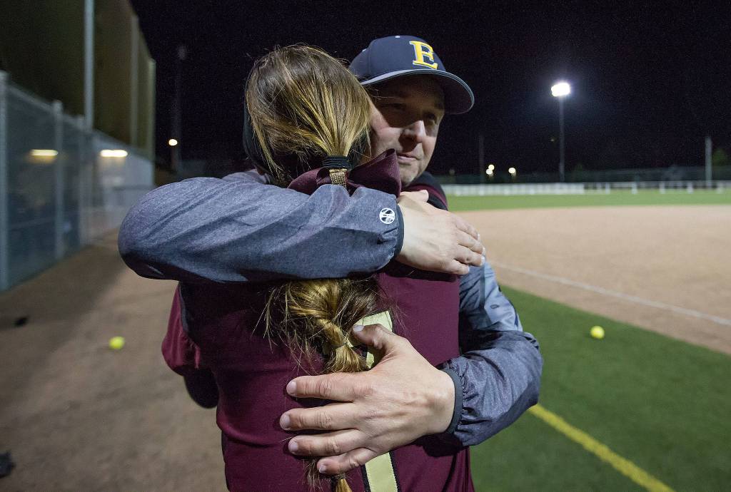Lakewood freshman pitcher Kassidy Millar hugs her father Everett coach Mike Millar after the Cougars lost 12-6 to Everett on Monday in Everett. (Andy Bronson / The Herald)