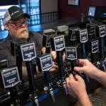 Owner Don Webb labels tap handles as he works to get Naked City Brewery ready for its soft opening on April 20 on Camano Island. (Andy Bronson / The Herald)