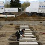 With modular apartments behind him, Bryce Knoth, a carpenter, works on framing at Twin Lakes Landing, a complex for families who struggle with consistent housing, on Tuesday in Marysville. Housing Hope teams up with Snohomish County on what is called coordinated entry for those who need a place to live. (Andy Bronson / The Herald)