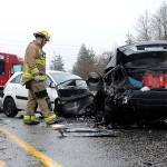 A firefighter looks over the aftermath of a head-on crash March 18 on U.S. 2, near Bickford Avenue, that cost a woman her life. The state is considering installing concrete median barriers on the highway between Bickford and the Pilchuck River. This crash happened near that stretch. (Doug Ramsay/ For The Herald)