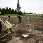 Taylor Berghuis (left) and Brandon Bailey (right) work on restoring the baseball field at Twin City Elementary in Stanwood on Saturday, April 1. (Ian Terry / The Herald)