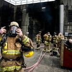 Photos by Ian Terry / The Herald                                Allen Buckner (left), a new Lynnwood Fire Department firefighter, adjusts his oxygen mask before beginning a training session at the Washington State Fire Training Academy near North Bend on Tuesday.