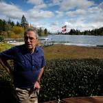 Marc Bhend stands on the patio of his home on Lake Serene in Everett on Friday, April 14. Bhend&rsquo;s yard has become completely waterlogged from months of high water levels in Lake Serene. (Ian Terry / The Herald)