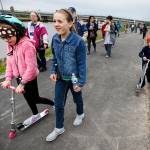Siblings Abbie (left), 10, Ellie (center), 12, and Josh Sarr (right), 7, walk and scooter their way along the Qwuloolt Waterfront Trail following its grand opening in Marysville on Saturday, April 22. (Ian Terry / The Herald)