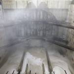 Water pours from the base, and a cloud of water vapor and concrete dust forms, as a massive tunneling machine nears breaking through a five-foot-thick concrete wall into the disassembly pit for the Highway 99 tunnel under Seattle on Tuesday. (AP Photo/Elaine Thompson)