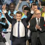 Independent centrist candidate Emmanuel Macron raises his arms as French Defense Minister Jean-Yves le Drian applauds during a meeting in Nantes, western France, on Wednesday, April 19. Polls suggest Macron has a good chance of coming out on top of Sunday&rsquo;s first round and reaching the May 7 runoff. (AP Photo/David Vincent)