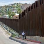 In this April 1 photo, a man in Nogales, Arizona, talks to his daughter and her mother who are standing on the other side of the border fence in Nogales, Mexico. (AP Photo/Rodrigo Abd)