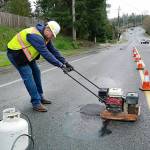 Mukilteo Public Works worker Jamieson McDaniels patches a pothole last month. Crews have been busy patching potholes on a near-daily basis. The city, like others, is seeing more potholes than usual due to the region&rsquo;s severe winter weather. Cold patches like this one are a temporary fix until warmer temperatures allow for more permanent hot asphalt fills. (Contributed photo)