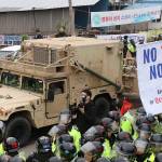 U.S. military vehicle moves past banners opposing a plan to deploy an advanced U.S. missile defense system called Terminal High-Altitude Area Defense, or THAAD, as South Korean police officers stand guard in Seongju, South Korea on Wednesday, April 26. South Korea says key parts of a contentious U.S. missile defense system have been installed a day after rival North Korea showed off its military power. (Kim Jun-hum/Yonhap via AP)