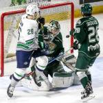 The Silvertips&rsquo; Carter Hart (center) and Devon Skoleski (right) battle with the Thunderbirds&rsquo; Nolan Volcan during a game on March 10, 2017, at ShoWare Center in Kent. (Kevin Clark / The Herald)