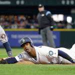 The Mariners&rsquo; Jean Segura (right) and Astros first baseman Yuli Gurriel look up for the call after Segura dove back to first base on a line drive by Mitch Haniger in the third inning of a game April 10, 2017, in Seattle. Segura was out on the double play. (AP Photo/Elaine Thompson)