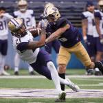 Washington wide receiver Quinten Pounds (21) pulls down a catch and is tackled by Washington defensive back Byron Murphy (6) during the Huskies&rsquo; annual spring scrimmage on April 22, 2017, in Seattle. (Joshua Bessex/The News Tribune)