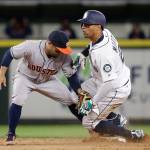 The Mariners&rsquo; Leonys Martin (right) looks up after stealing second base as the Astros&rsquo; Jose Altuve puts on a tag during a game April 10, 2017, in Seattle. (AP Photo/Elaine Thompson)