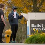 Maximillian Roberts, 21, watches as Angel Green, 20, takes a selfie before dropping off her ballot in her first presidential race November in Everett. (Andy Bronson / Herald file)