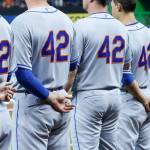New York Mets players, all wearing No. 42 in honor of Jackie Robinson, stand during the singing of the national anthem before a game Saturday against the Marlins in Miami. (AP Photo/Wilfredo Lee)