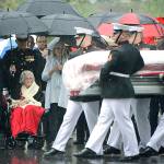Annie Glenn (seated), widow of John Glenn, watches as members of the U.S. Marine Corps from Marine Barracks Washington carry the casket of her husband during his graveside service at Arlington National Cemetery in Arlington, Virginia, on Thursday, April 6. (U.S. Army photo by Rachel Larue/Arlington National Cemetery via AP)