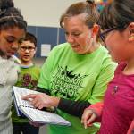 Madison Elementary School fifth-graders Jaila Snowden (left) Jaedin Chum and Jaimy Moreno (right) listen to their teacher, Teresa O&rsquo;Shea talk about her deep-dish brownie recipe. O&rsquo;Shea contributed five recipes in the book. (Dan Bates / The Herald)
