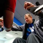 Walker helps Duitsman position himself in a custom Uppertone exercise apparatus. (Dan Bates / The Herald)